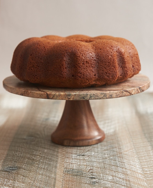 Amaretto Cake on a wood and marble cake stand.