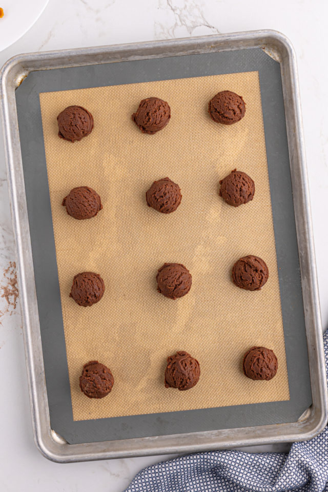 Balls of chocolate cookie dough on baking sheet