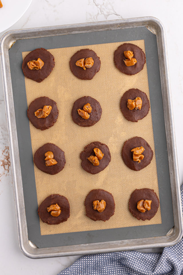 Overhead view of chocolate cookie dough circles with caramels in center