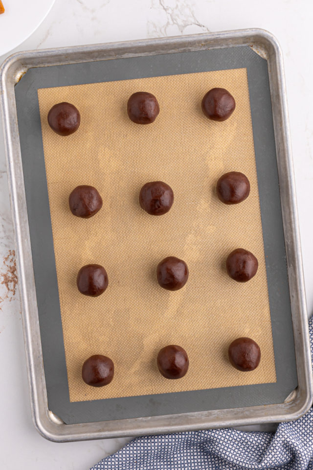 Overhead view of chocolate caramel cookies on baking sheet before baking