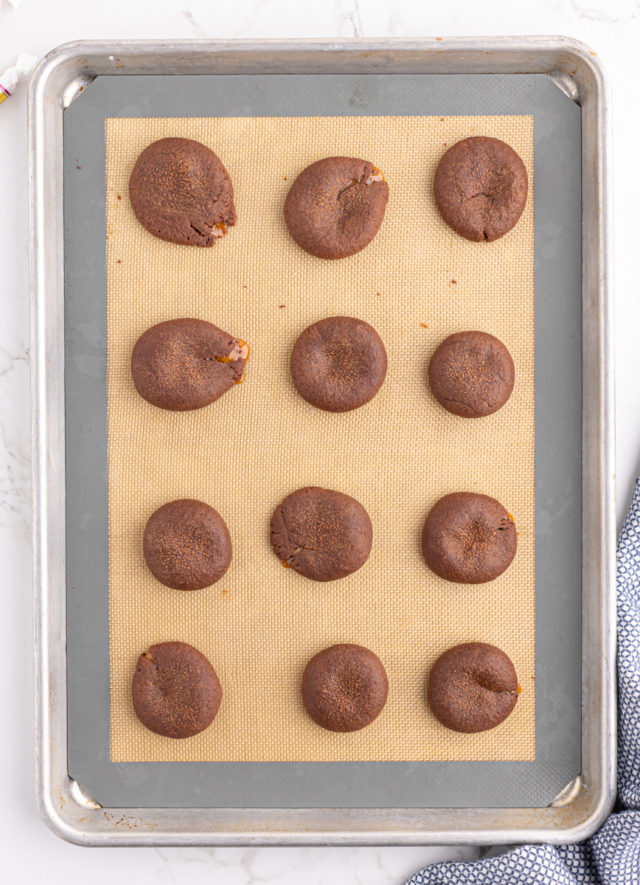 Overhead view of baked chocolate caramel cookies on silpat lined baking sheet