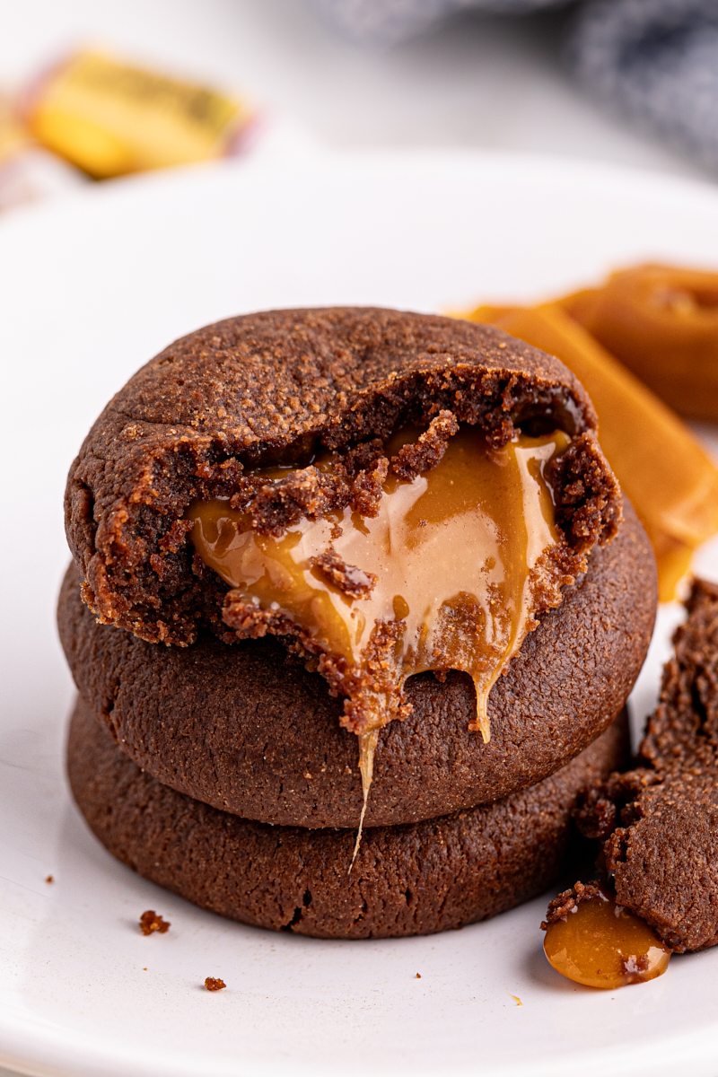 Stack of chocolate caramel cookies, with top cookie bitten to show center