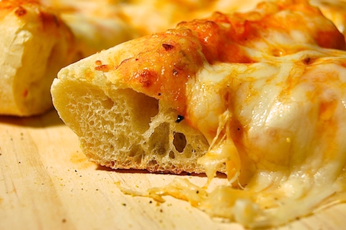 Alton Brown's Pizza Crust made into a homemade pizza topped with sauce and cheese.