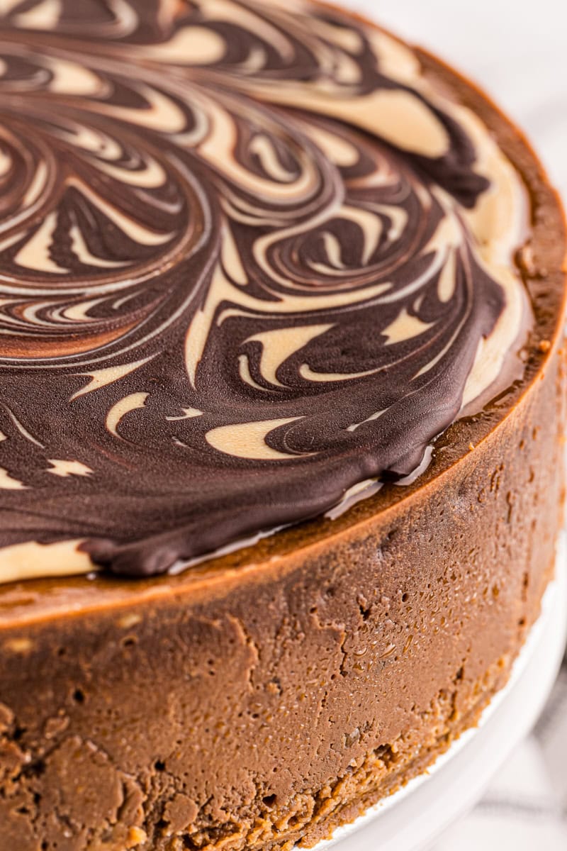 Whole chocolate peanut butter cheesecake on cake stand