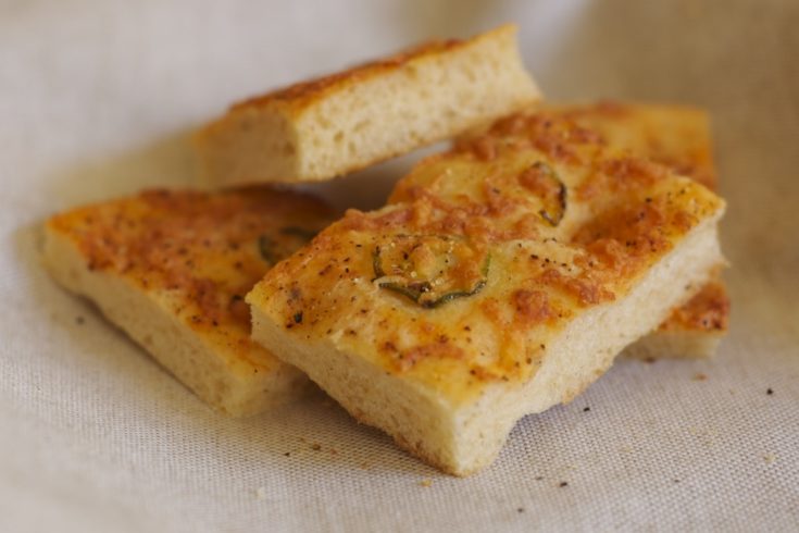 Spicy, cheesy jalapeno focaccia bread stacked on a countertop.