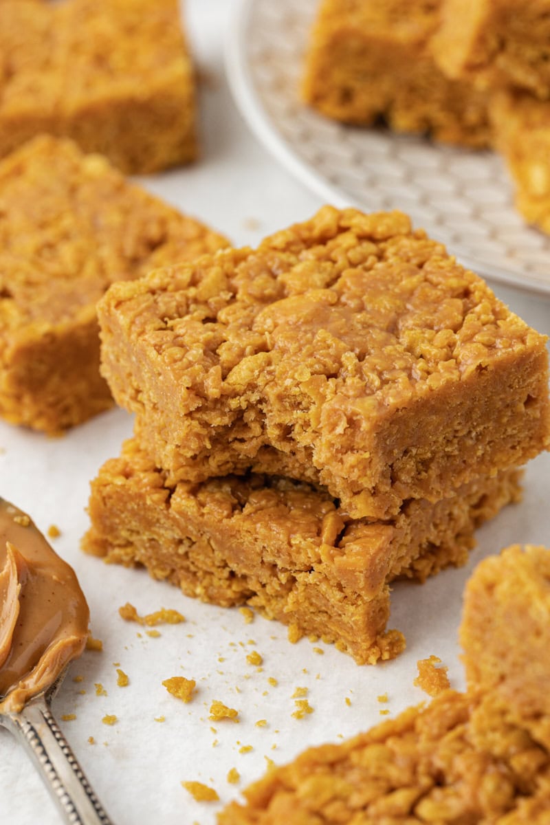 Two stacked peanut butter cornflake bars, with bite taken out of corner of top bar