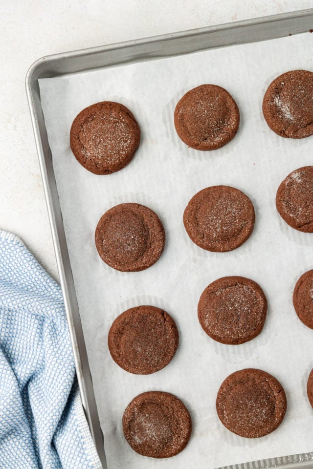 Overhead view of peanut butter-filled chocolate cookies on parchment-lined baking sheet