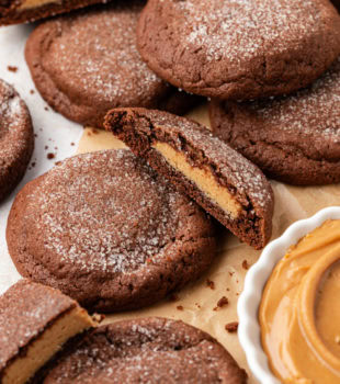 Chewy peanut butter-filled chocolate cookies, with some cut in half to show filling