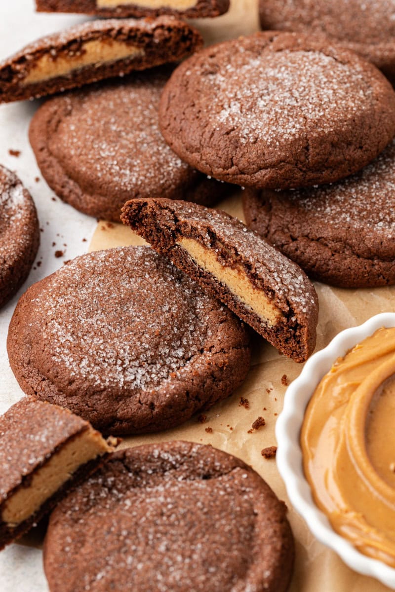 Chewy peanut butter-filled chocolate cookies, with some cut in half to show filling