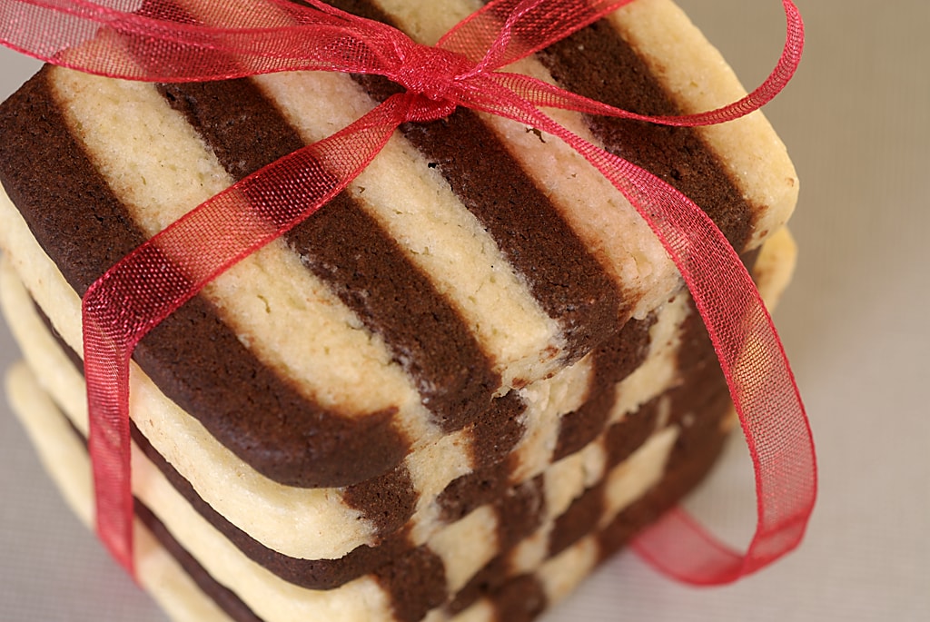 A stack of black and white striped cookies tied with a decorative red ribbon.