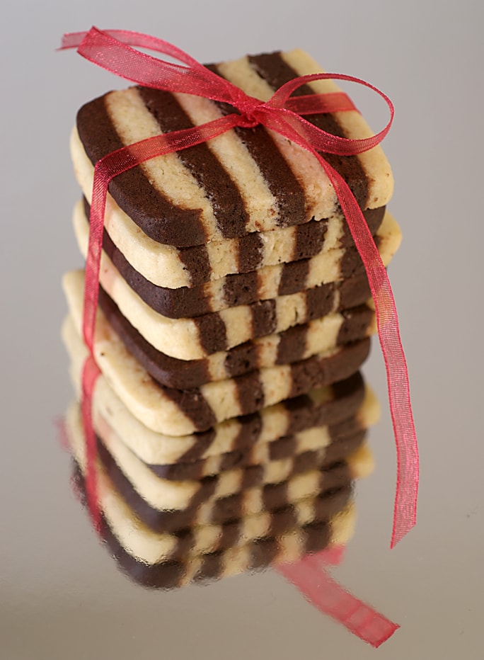 A stack of black and white striped cookies tied with a decorative red ribbon.