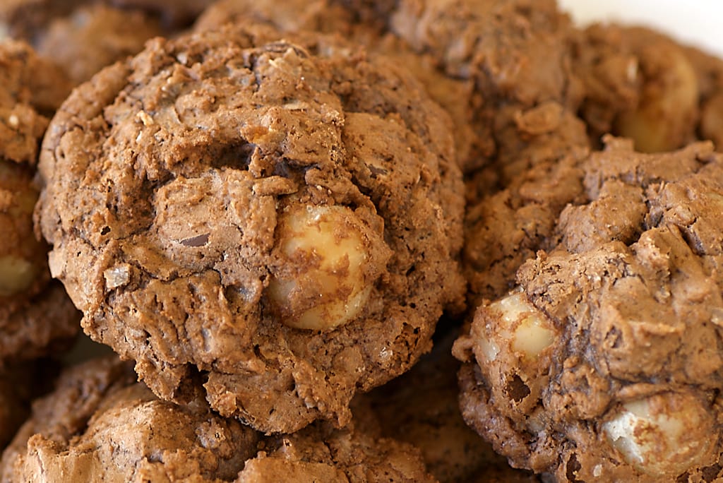 Decadent chocolate macadamia nut clusters arranged in a pile.