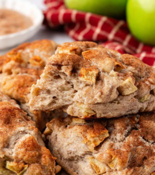 Flaky apple cinnamon scones stacked on countertop