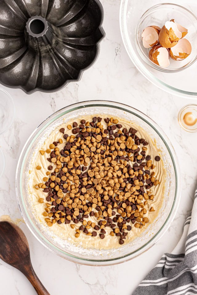 Overhead view of chocolate and peanut butter chips added to cake batter