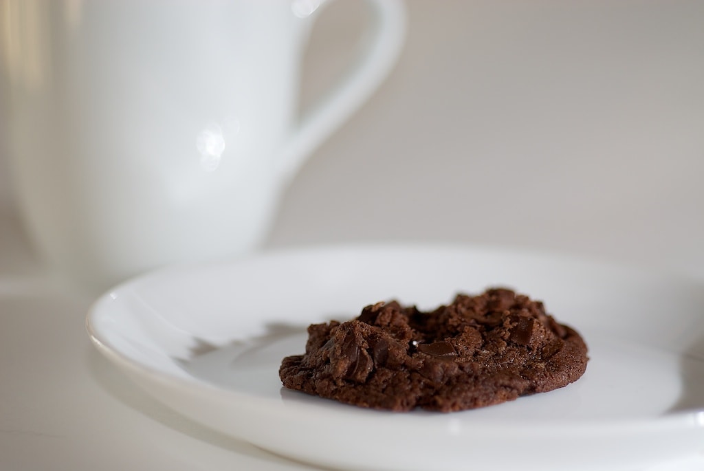 A chocolate cookie on a white plate