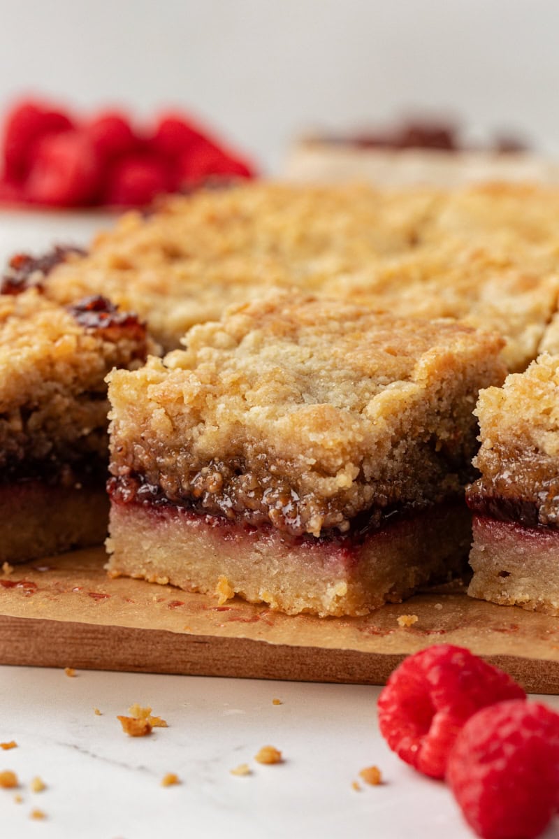 Side view of raspberry crumble bars on board to show layers