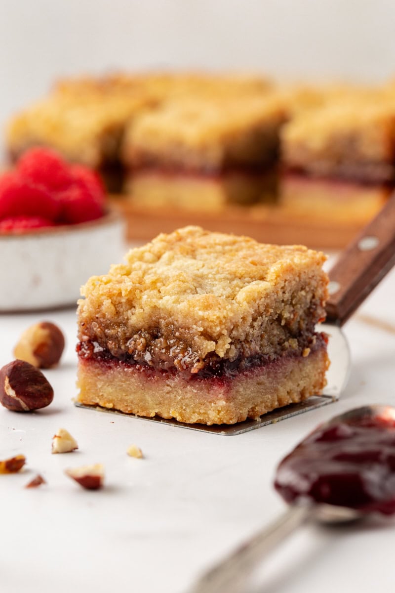 Buttery raspberry crumble bar on spatula