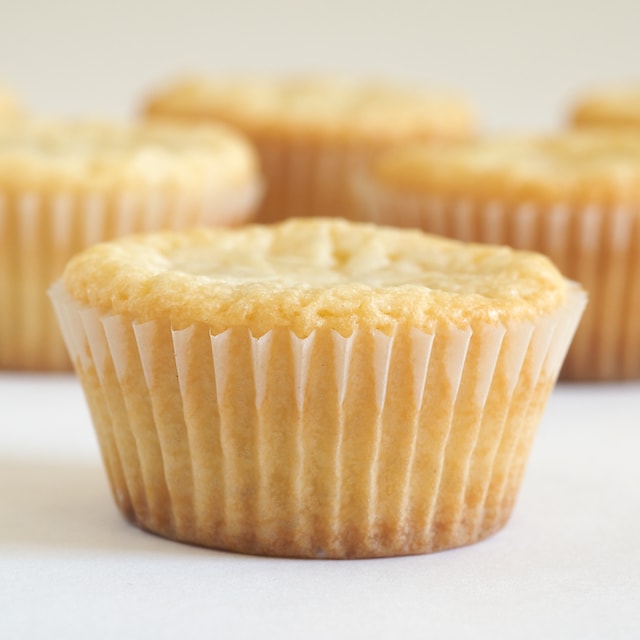 White Chocolate Chip Blondies in paper wrappers on a white surface