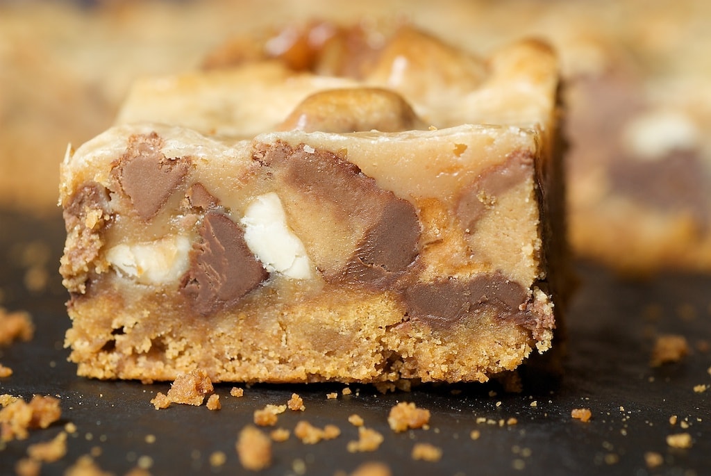 Peanut Butter Candy Bar Squares on a black surface