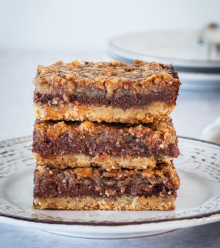 stack of chocolate pecan cheesecake bars on a plate