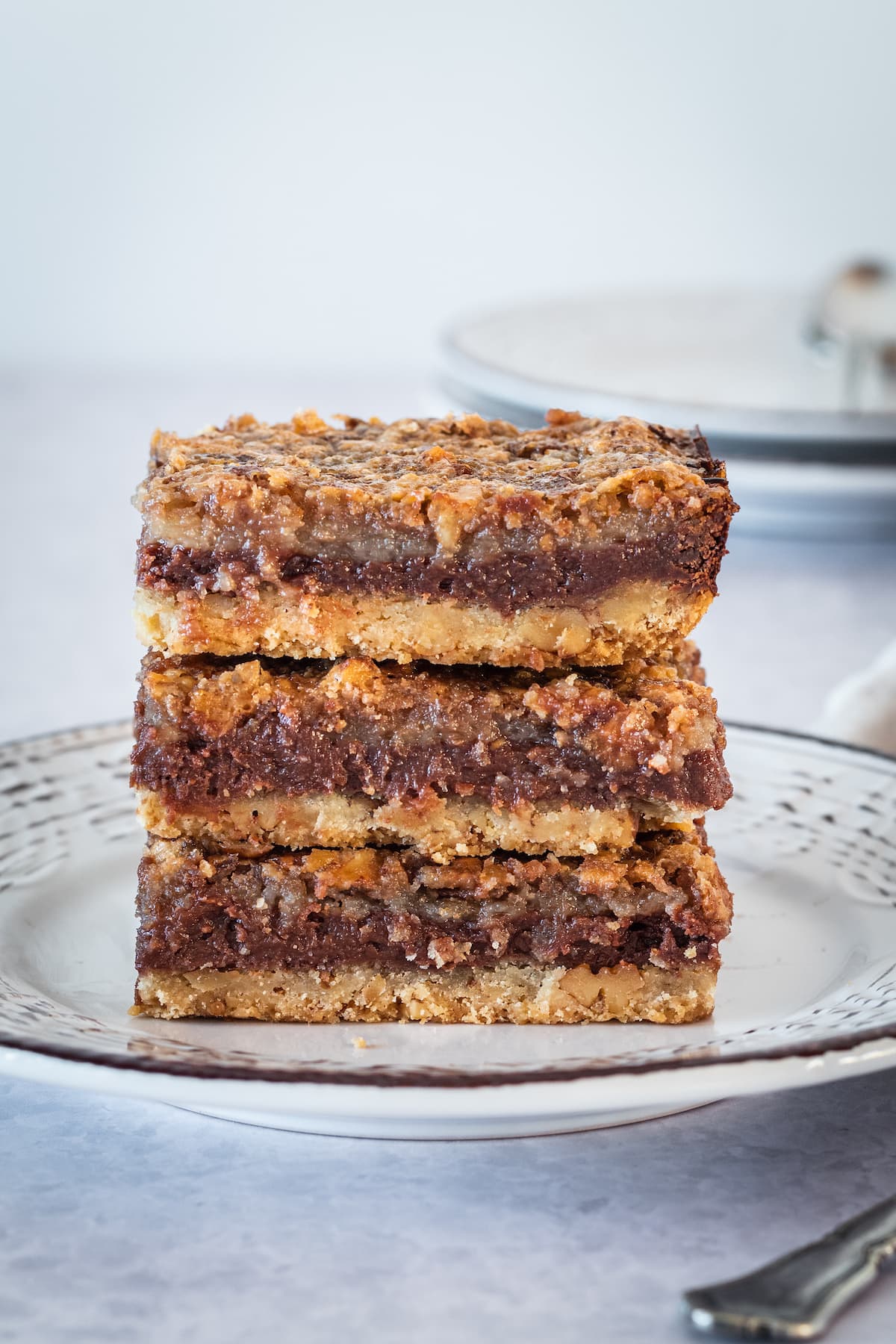 stack of chocolate pecan cheesecake bars on a plate