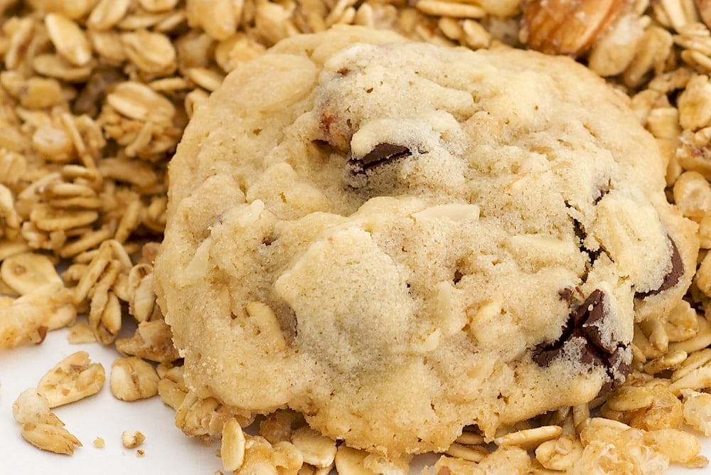 Granola Cookies with Chocolate and Roasted Almonds sitting on a small pile of granola