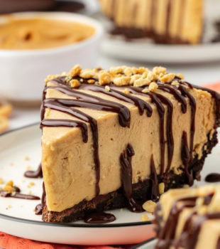 Slice of peanut butter pie on plate with chopped peanuts for garnish