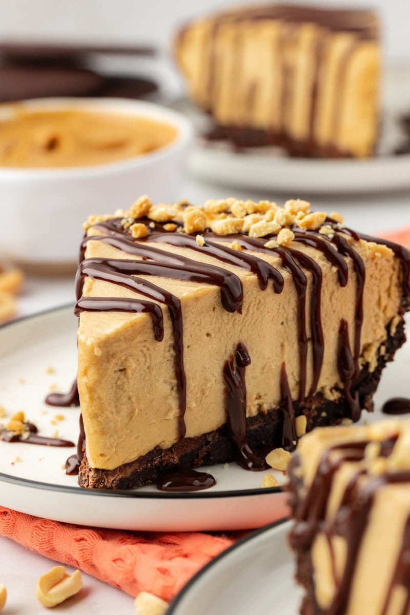 Slice of peanut butter pie on plate with chopped peanuts for garnish