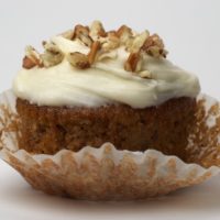 Hummingbird Cupcake topped with cream cheese frosting and chopped nuts
