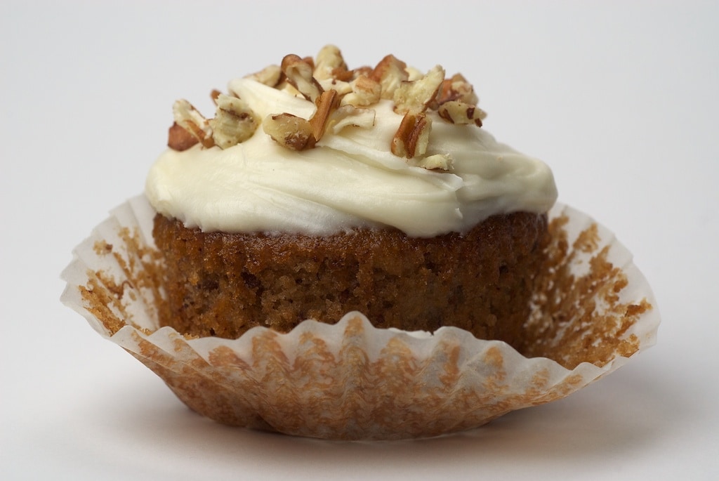 Hummingbird Cupcake topped with cream cheese frosting and chopped nuts