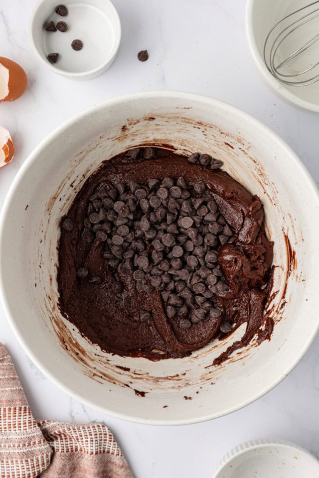 Chocolate chips added to bowl of cookie dough