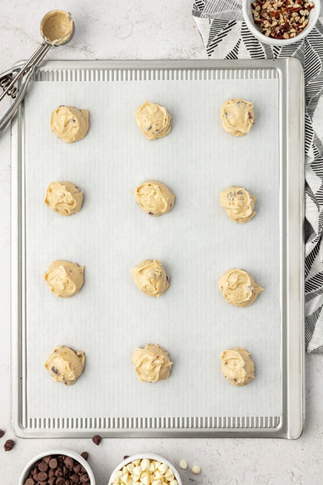 Overhead view of black and white chocolate chip cookie dough on parchment-lined baking sheet