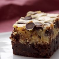 Black bottom brownie with chocolate chips on a plate.