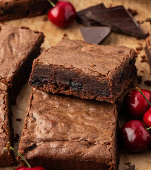 Dark chocolate sour cherry brownies on parchment paper