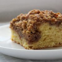 Slice of cinnamon coffee cake with a cream cheese swirl on a plate.