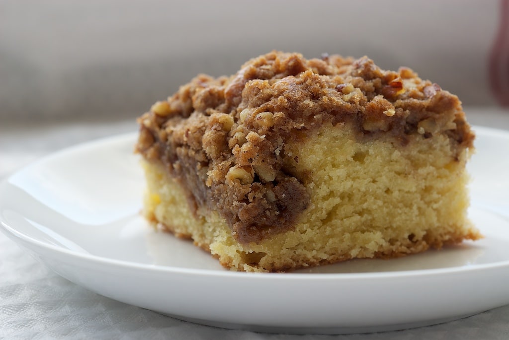 Slice of cinnamon coffee cake with a cream cheese swirl on a plate.