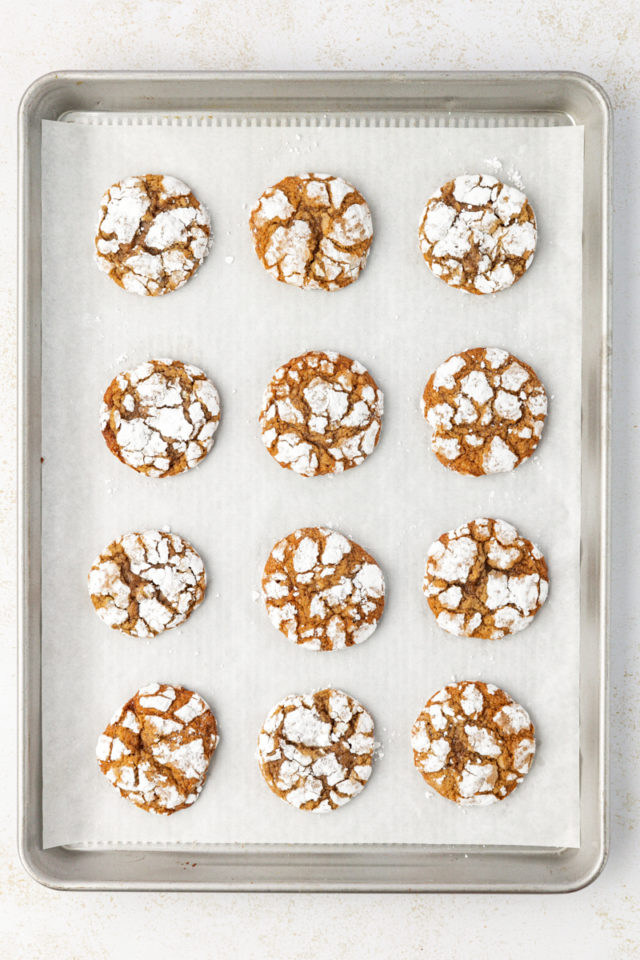 Overhead view of brown sugar crinkle cookies on parchment-lined baking sheet