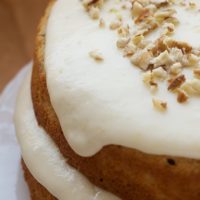 Pecan Layer Cake with Banana Icing topped with chopped pecans.