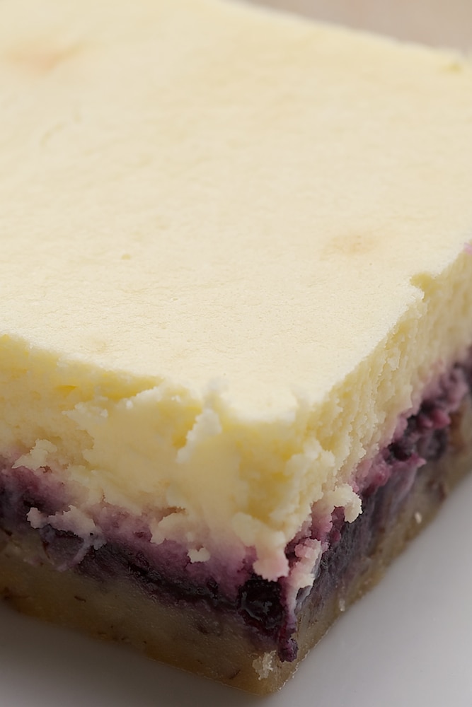 Lemon Blueberry Cheesecake Bars combine a nutty crust, blueberry preserves, and a lemony cheesecake for an irresistible dessert. - Bake or Break