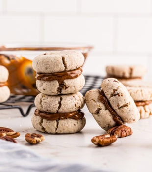 Stack of two cream cheese shortbread sandwiches with another cookie leaning against it