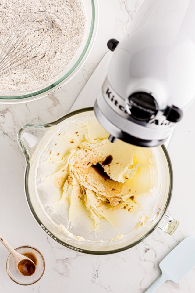 Overhead view of vanilla added to wet ingredients in stand mixer