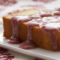 Cream Cheese Pound Cake with Strawberry-White Chocolate Sauce on a white plate.