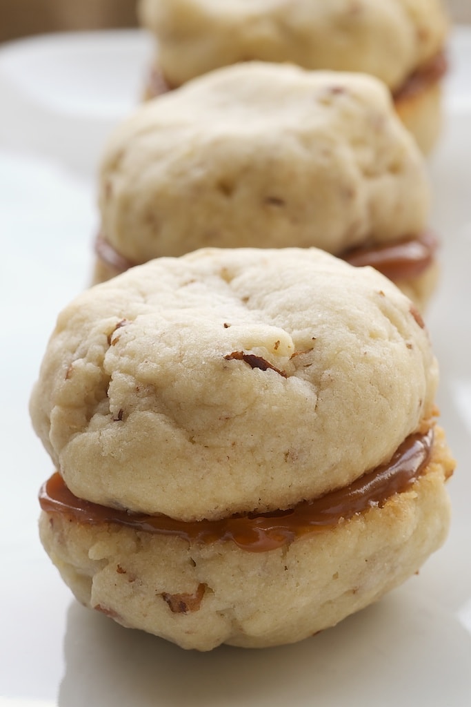 Row of cream cheese shortbread dulce de leche cookies on a plate.