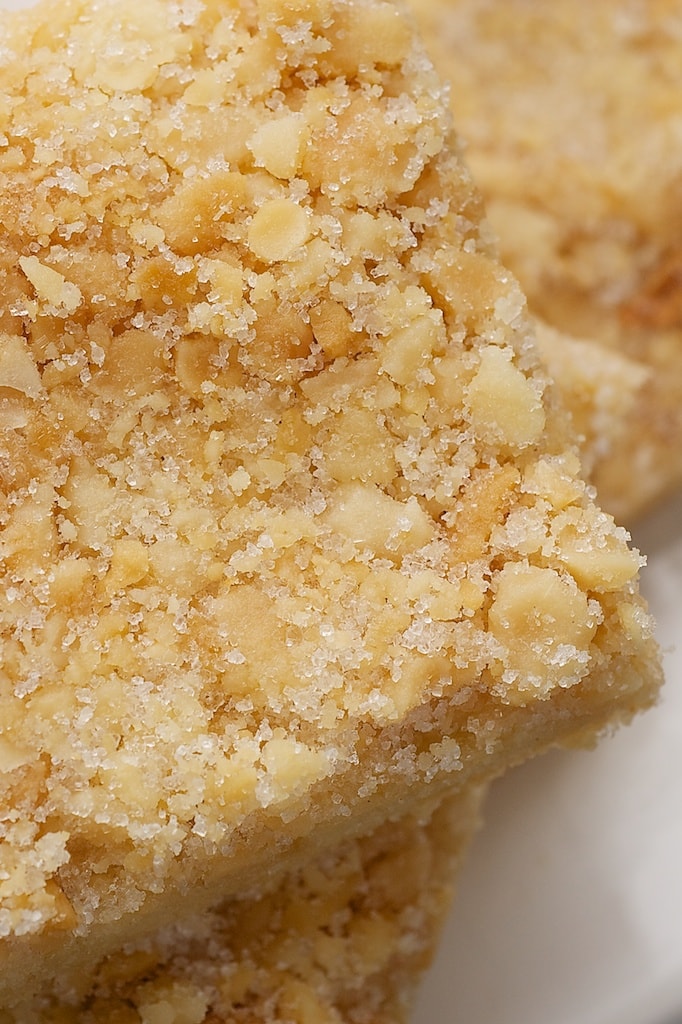 Macadamia nut shortbread cookie bars stacked on a plate.