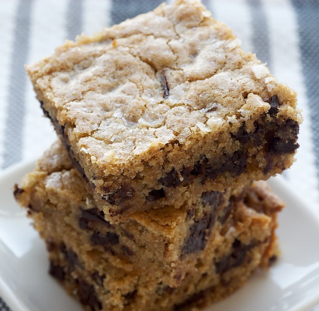 Salty Chocolate Chunk Blondies stacked on a white plate