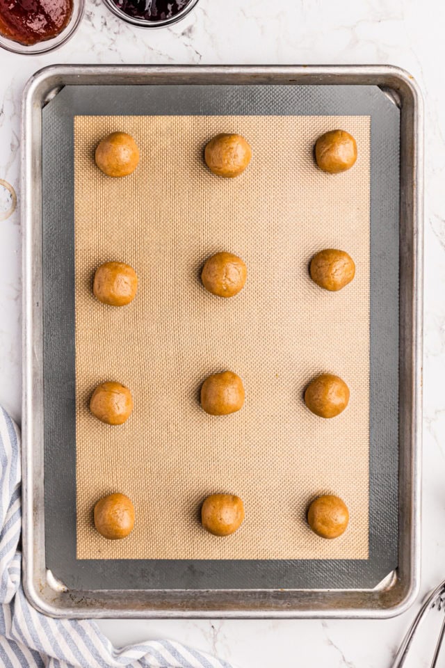 Balls of peanut butter cookie dough on baking sheet