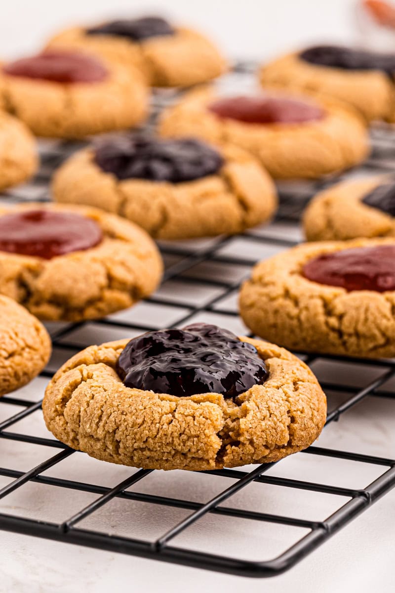 Peanut butter and jelly thumbprint cookies cooling on wire rack