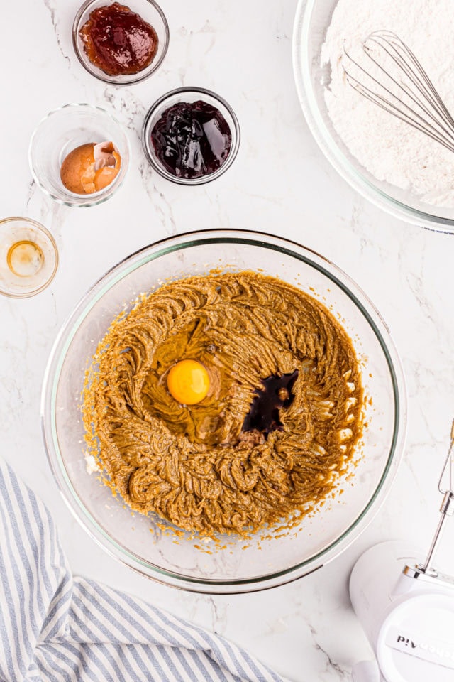 Egg and vanilla added to bowl of wet ingredients for cookies