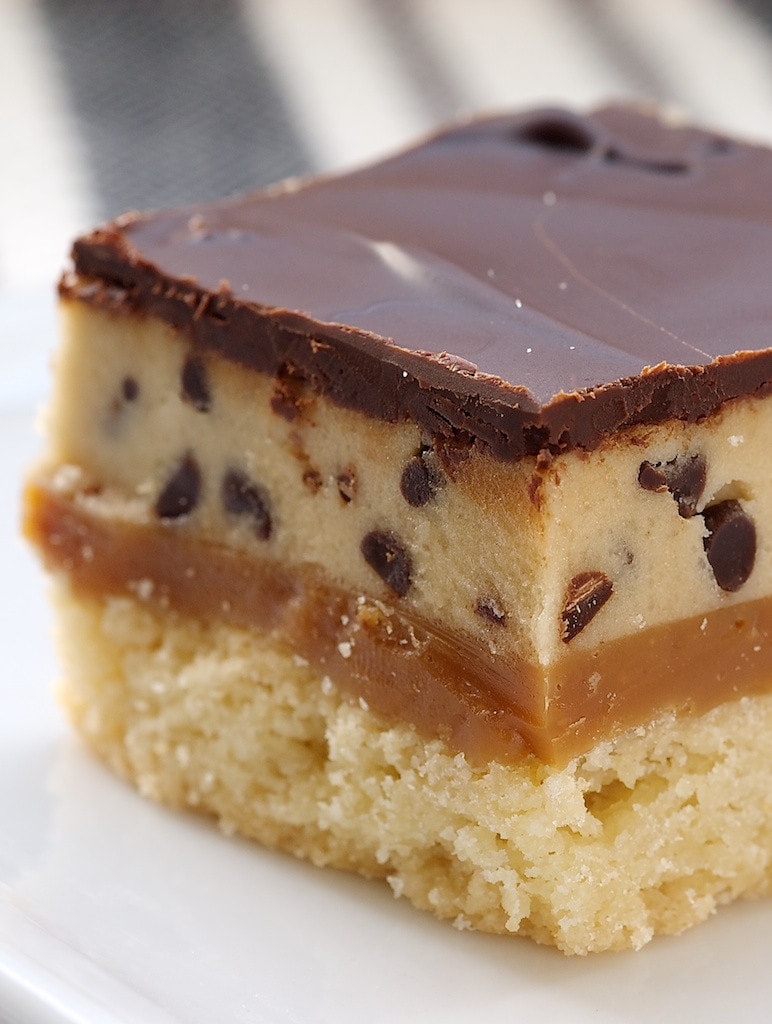 Cookie dough billionaire bar topped with chocolate glaze on a plate.