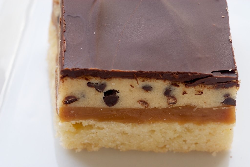 Cookie dough billionaire bar on a white plate.